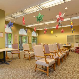 A spacious waiting area with rows of chairs, colorful ceiling decorations, and ample lighting.