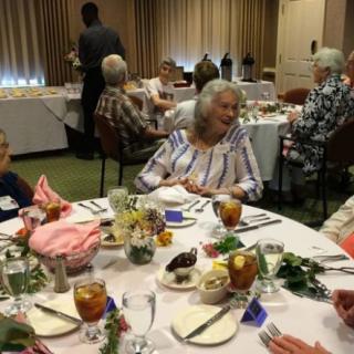 A group of people enjoying a meal at a formal indoor gathering.
