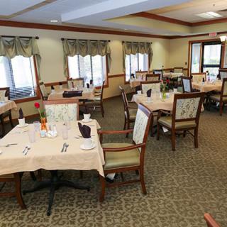 A neatly arranged dining room with tables set for guests.