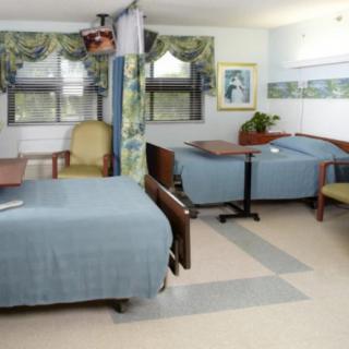 A hospital room with two beds and medical equipment.