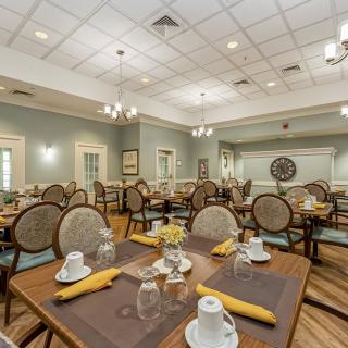 A spacious and elegantly decorated dining room with neatly arranged tables and chairs.