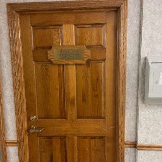 A wooden office door with a plaque.