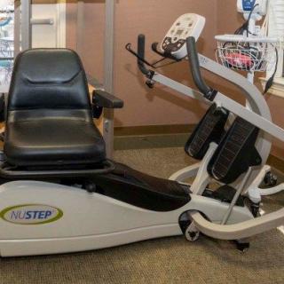 A recumbent exercise machine positioned in a fitness room.