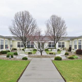 A neatly landscaped courtyard with benches and an overcast sky.