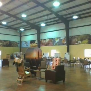 An open interior space with several chairs and tables arranged under a high ceiling.