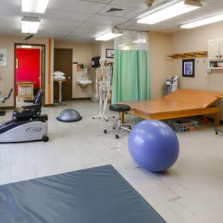 An overview of a physical therapy room equipped for rehabilitation and exercise.