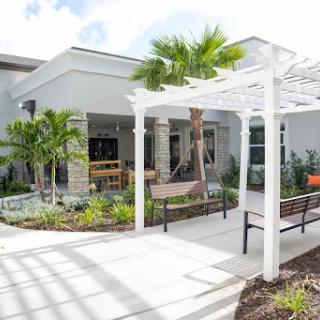 A modern outdoor seating area surrounded by lush greenery and architectural elements.