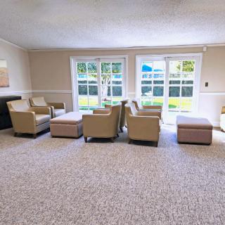 A spacious living room with comfortable seating and large windows letting in natural light.