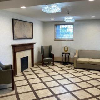 A modern living room with a sofa, armchair, and fireplace.