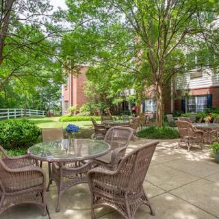 A serene outdoor patio area with wicker furniture and lush green surroundings.