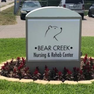 Sign for Bear Creek Nursing & Rehab Center displayed outdoors.