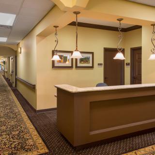 A well-lit reception area in an office building with a desk and hallway.