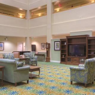 Spacious hotel lobby with comfortable seating and a large television.