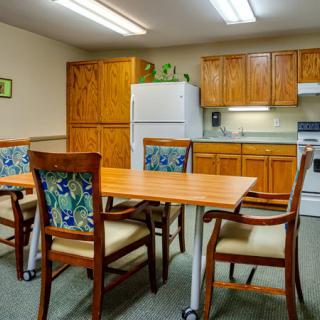 A cozy kitchen and dining area with wooden cabinets, a table, and chairs.