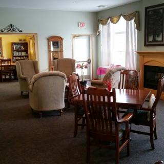 A cozy living room with comfortable seating, a fireplace, and large windows.