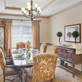 A well-decorated dining room with a chandelier, set table, and elegant furnishings.