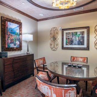 A professionally decorated meeting room featuring a round table, stylish chairs, and contemporary artwork.