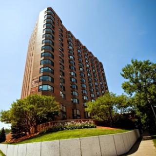 A modern high-rise residential building against a clear blue sky.
