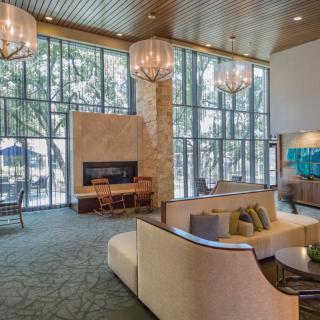 A modern lobby with comfortable seating, a fireplace, and large windows.