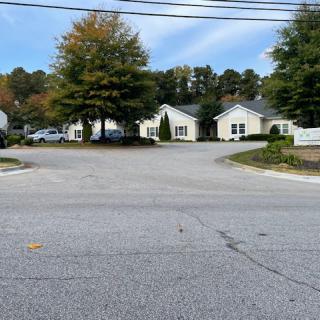 A quiet suburban street with houses and trees on a sunny day.