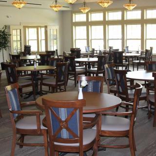 An empty dining room with neatly arranged tables and chairs.
