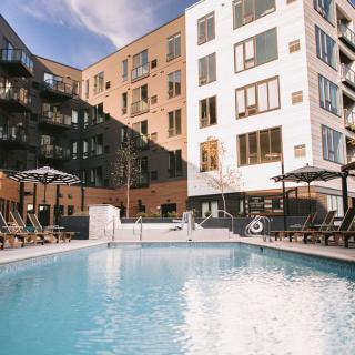 Modern apartment complex with a large outdoor pool.