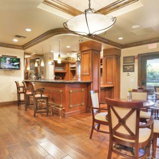A luxurious kitchen and bar area with wooden floors and elegant seating.