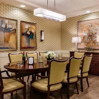 A well-decorated dining room featuring elegant furniture and artistic wall decor.