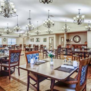 Spacious dining room with elegant chandeliers and well-set tables.