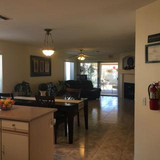 Spacious open-plan living and dining area with a kitchen island, illuminated by natural light.