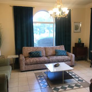 A cozy living room featuring a stylish sofa, elegant curtains, and a modern coffee table.