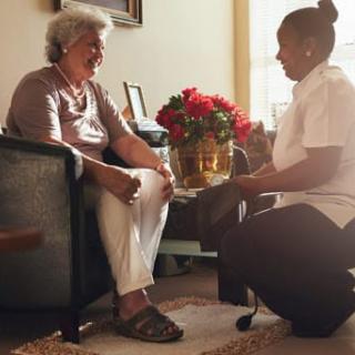 A caregiver assisting an elderly person during a home visit.