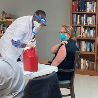 A healthcare professional administering a vaccine to a patient in a clinic setting.