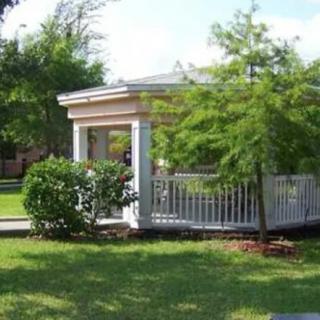 A gazebo surrounded by lush greenery in a garden setting.