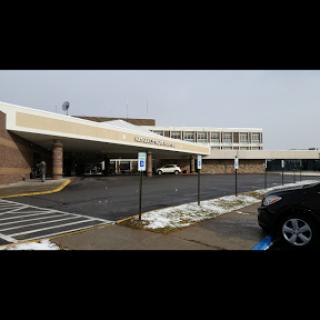 A view of a commercial building with a parking lot, showing some remnants of snow.