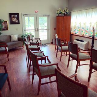 A cozy waiting room with comfortable chairs arranged in a circle, welcoming natural light filtering through the windows.