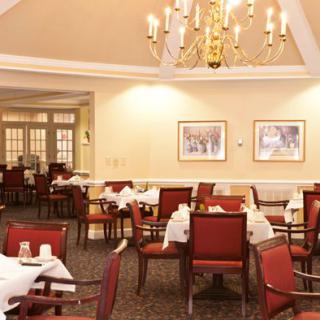 An elegant dining room with neatly arranged tables and a chandelier.