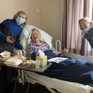 Visitors bring joy and companionship to a patient in a hospital room.