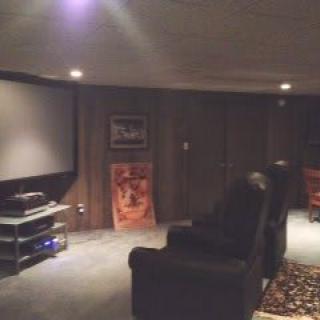 A cozy home theater setup with recliner chairs and a large screen, perfect for movie nights.