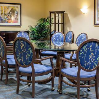 A beautifully decorated dining area featuring a round table surrounded by floral-patterned chairs.