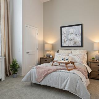 A cozy, elegantly decorated bedroom with a neatly made bed and soft lighting.