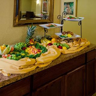 A decorative buffet display featuring an assortment of colorful fruits, beautifully arranged on a countertop.