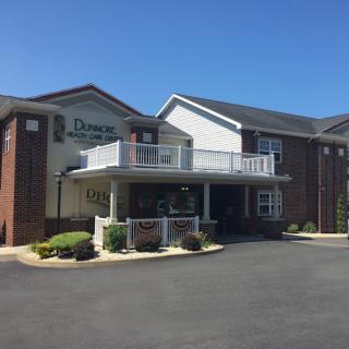 A sunny view of a two-story hotel with a welcoming entrance.