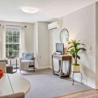 A cozy living room with a TV, comfortable seating, and plenty of natural light.