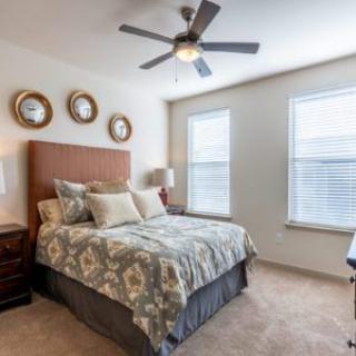 A cozy bedroom with a stylish bed, pillows, and wall decor.