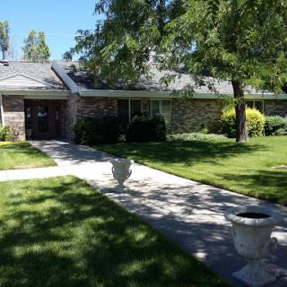 A beautiful residential home surrounded by lush greenery and a well-maintained pathway.