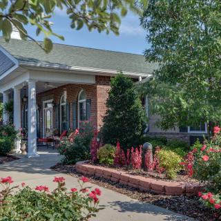 A charming house with a beautifully landscaped garden featuring colorful flowers and lush greenery.