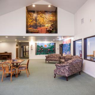 A spacious lobby with comfortable seating arrangements, featuring colorful artwork on the walls.