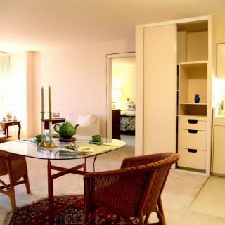 A cozy dining area with a glass table, wicker chairs, and elegant decor.