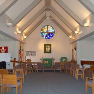 Interior view of a church with stained glass and altar.